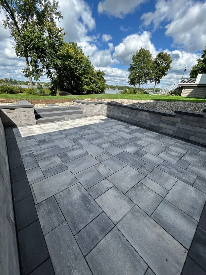 Patio with gray pavers overlooking a scenic landscape and blue sky. Ideal outdoor living space.