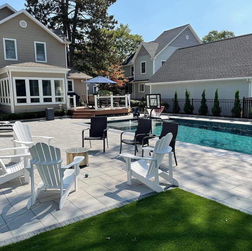 Modern backyard pool area with lounge chairs, spa, and well-maintained landscaping.